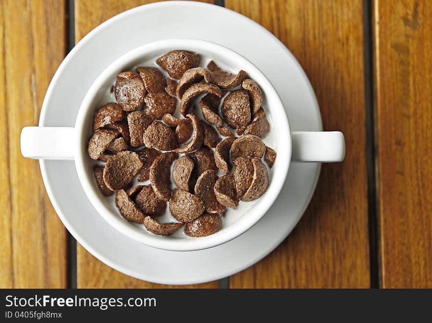 Cocoa cereal in white cup on a wood table