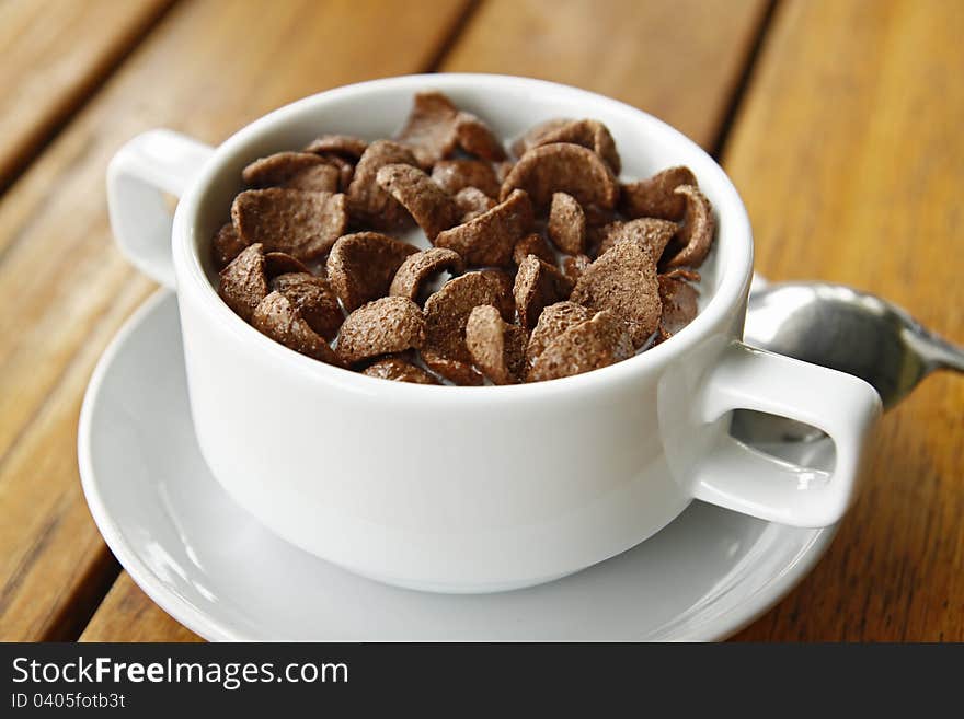 Cocoa cereal in white cup on a wood table