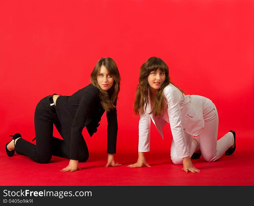 Sisters twins in black and white costumes posing in studio