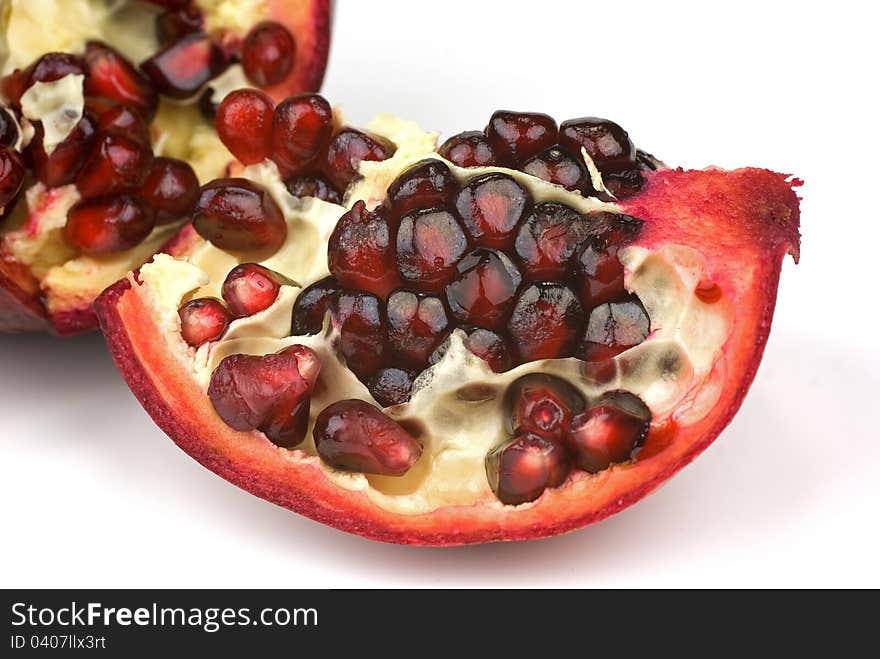 Juicy pomegranate and its half with leaves. Isolated on a white background