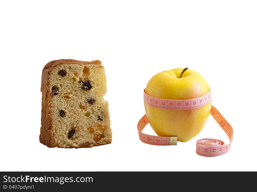 Pies of panettone and fresh yellow apple with measuring tape isolated on white. Pies of panettone and fresh yellow apple with measuring tape isolated on white