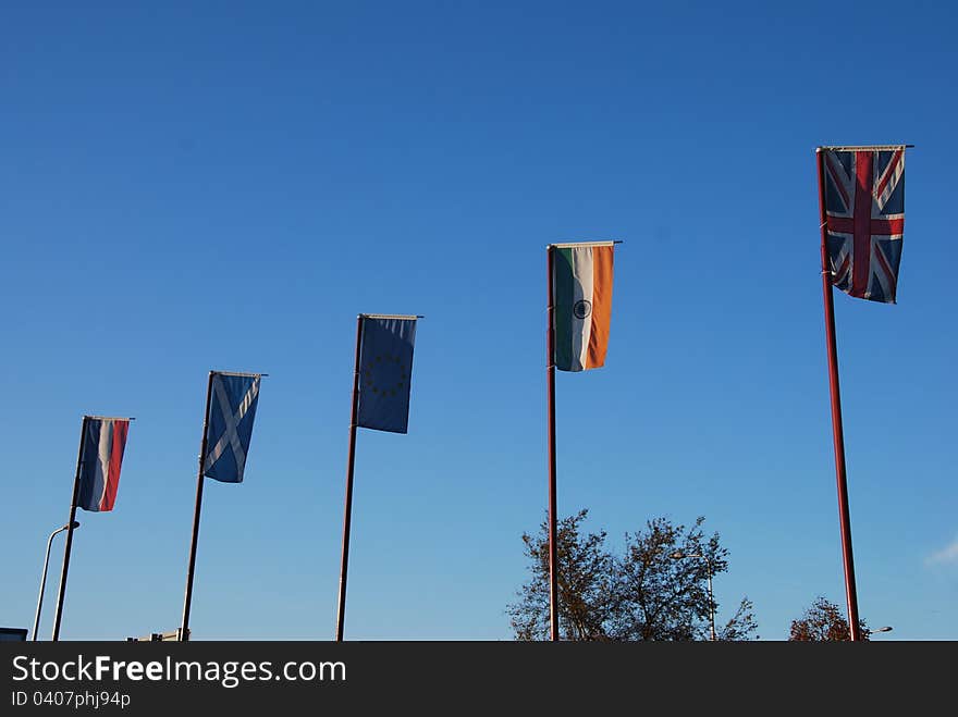 A variety of national flags fly from flag poles outside a hotel