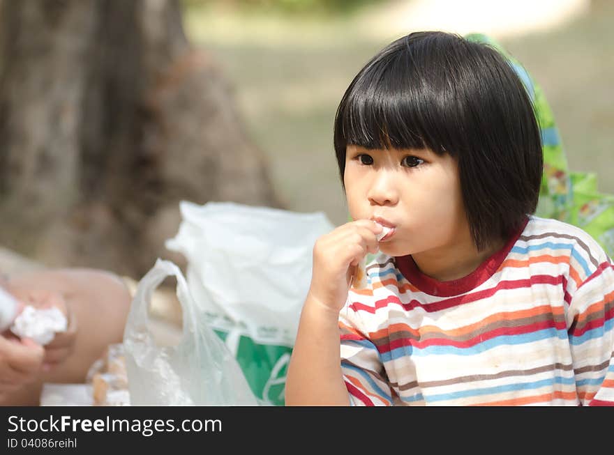 Asian Little Girl Eating Outdoor