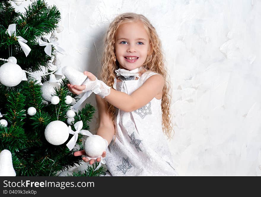 Cute blonde girl and Christmas tree with white decoration. Cute blonde girl and Christmas tree with white decoration