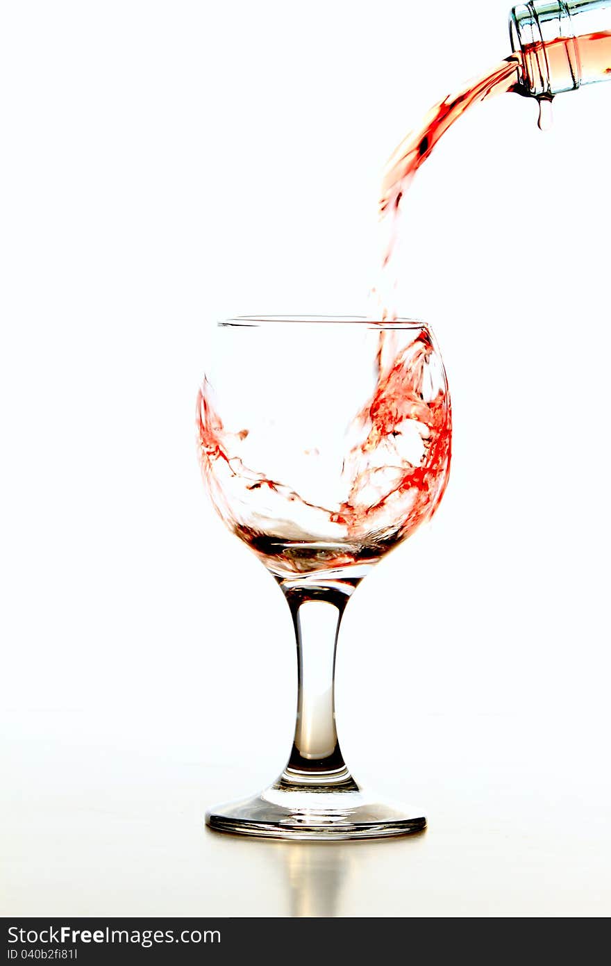 Pouring rose wine in glass isolated on white background. Pouring rose wine in glass isolated on white background