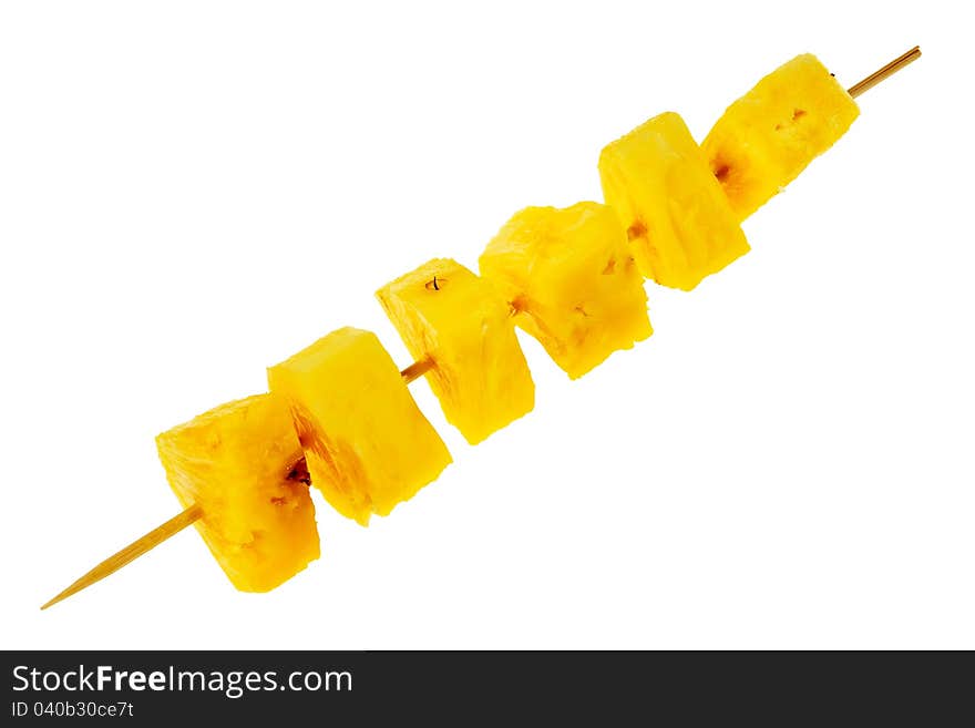 Fresh, raw pineapple chunks nailed on wooden stick isolated over white background.