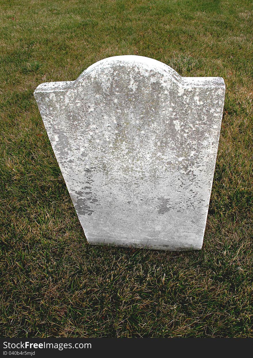 Old, plain, weathered, unmarked vintage marble headstone with a grass background. Old, plain, weathered, unmarked vintage marble headstone with a grass background.