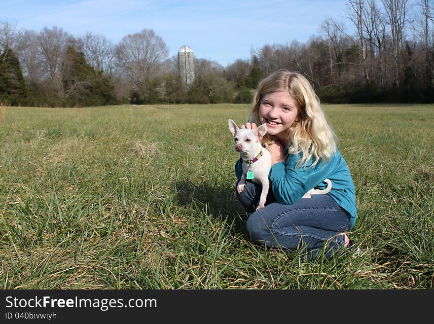 Smiling young girl and her dog in a country setting. Smiling young girl and her dog in a country setting.