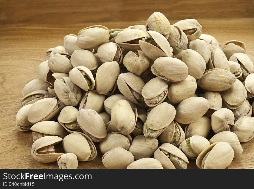 Roasted Pistachio nuts on a wood background. Roasted Pistachio nuts on a wood background