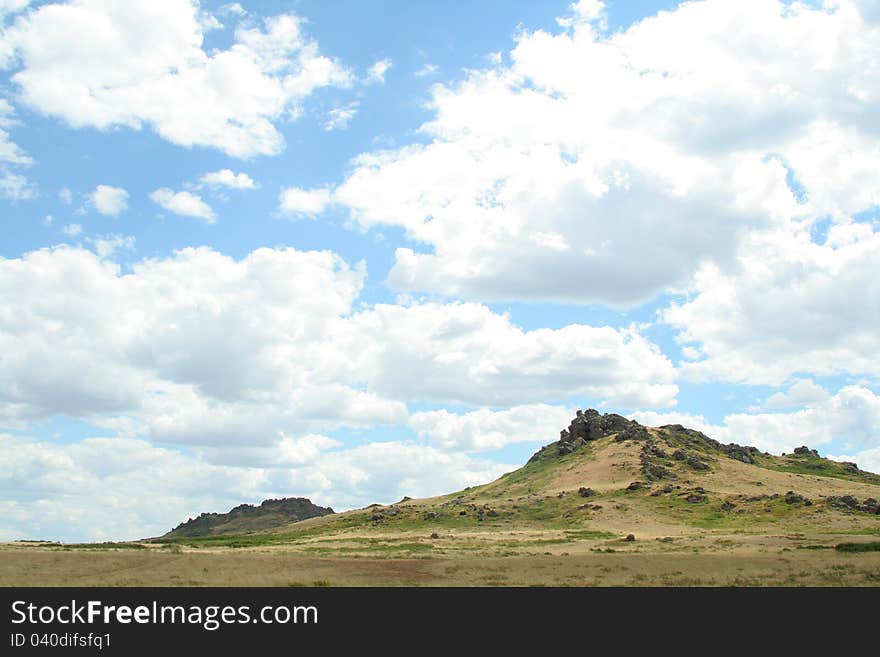 Steppe landscape. hill covered grass. sky with clouds