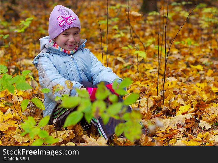 Girls kid smiling in autumn leaves background