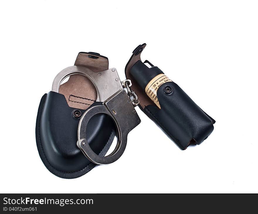 Manacles and gas pulverizer for police body in black leather case on white background