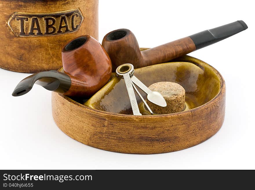 Two pipes and tobacco tin on white background. Two pipes and tobacco tin on white background