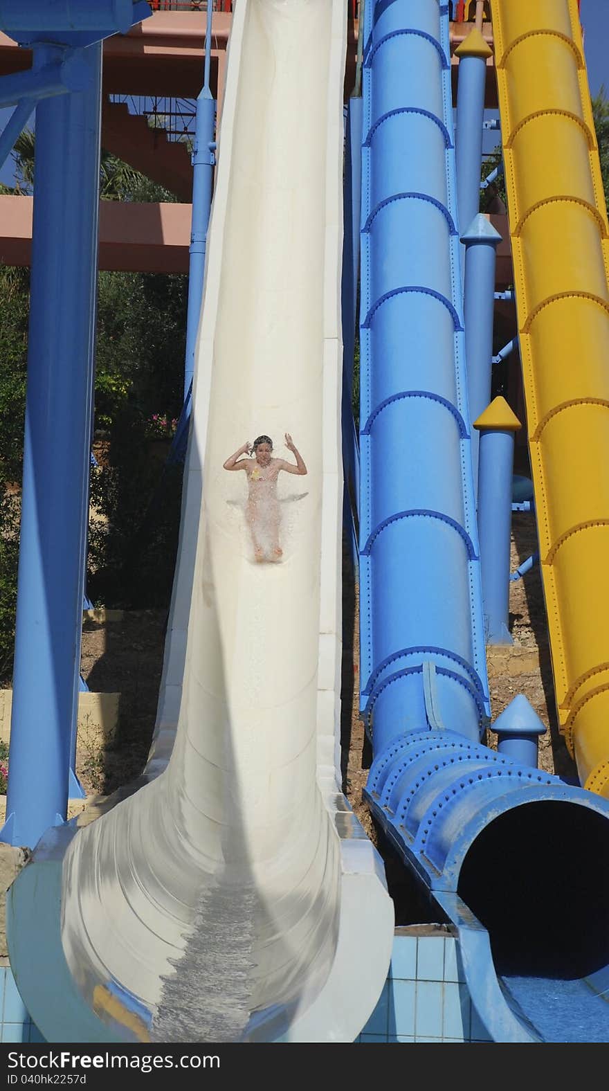 Tenage girl on white water slide, accelerating. Tenage girl on white water slide, accelerating