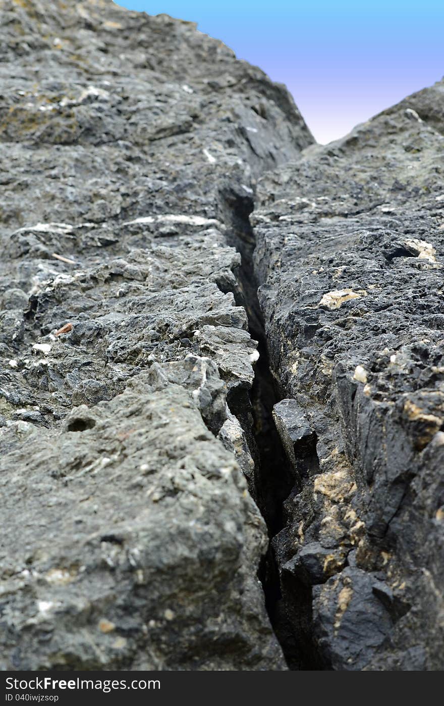 Rock along the beach with a deep crack. Rock along the beach with a deep crack