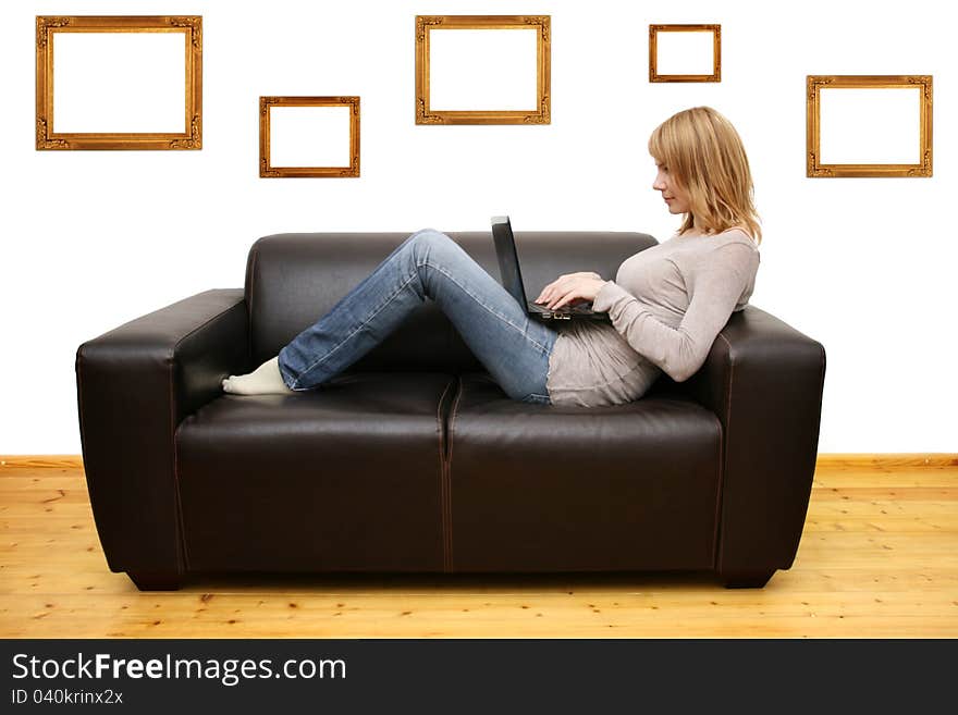 Young woman lying on a sofa and using a laptop