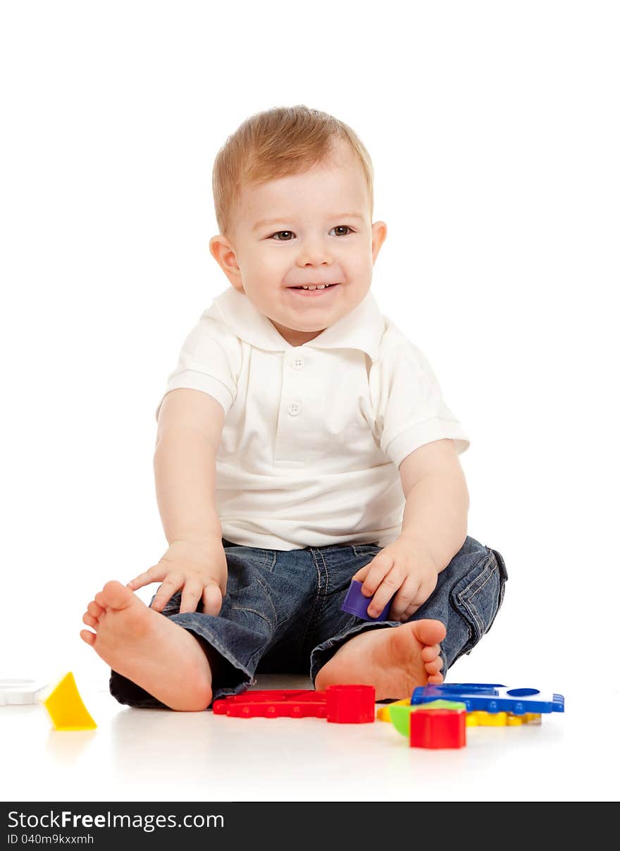 Cute little child is playing with toys while sitting on floor. Cute little child is playing with toys while sitting on floor