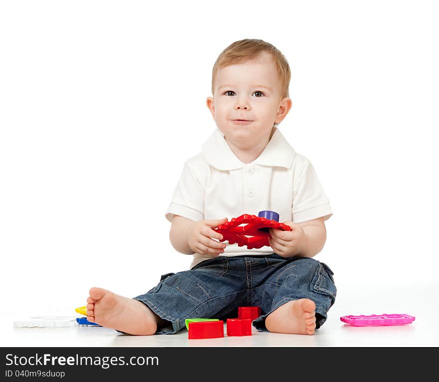 Cute little child is playing with toys while sitting on floor. Cute little child is playing with toys while sitting on floor