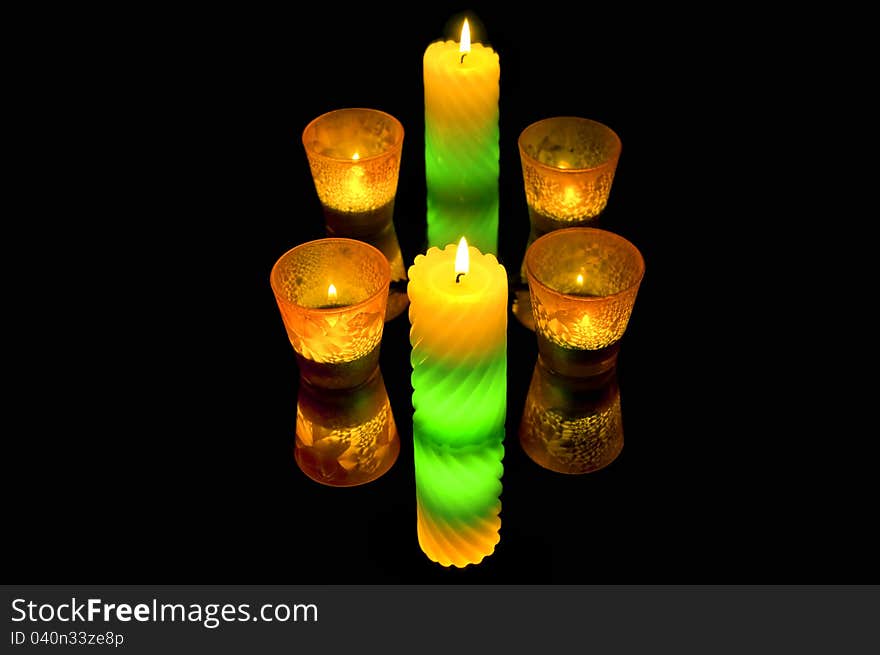 A few burning candles in the dark. mirroring. A few burning candles in the dark. mirroring