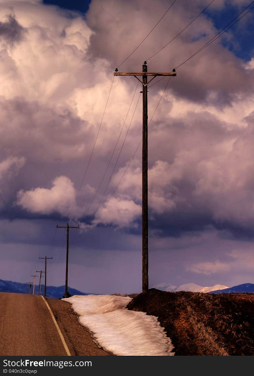 This image of the rural road flanked with snow banks and telephone poles was taken during late winter in NW Montana as a snow squall approached. This image of the rural road flanked with snow banks and telephone poles was taken during late winter in NW Montana as a snow squall approached.