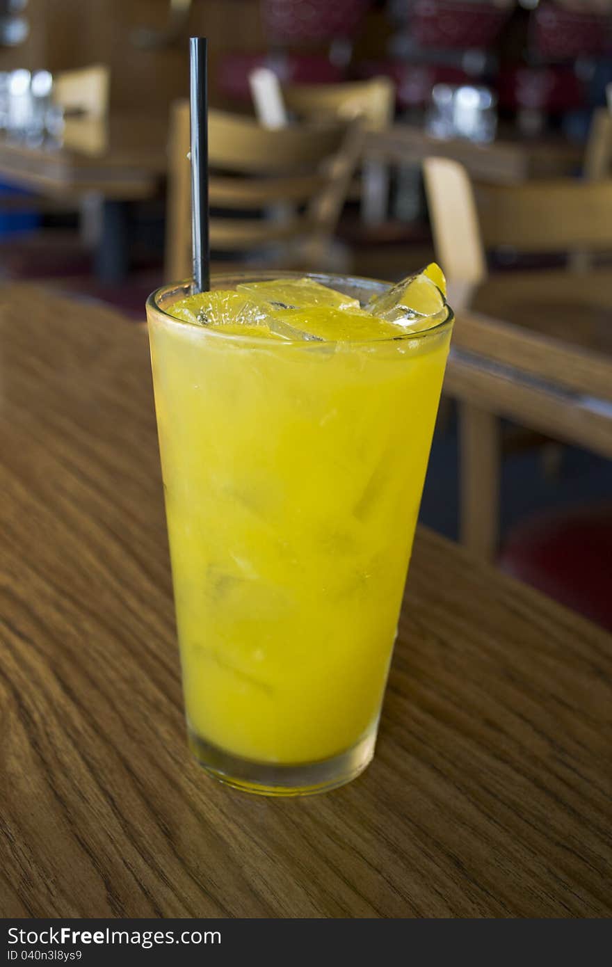 Pineapple with ice and vodka in a tetrahedral glass with black straw. Pineapple with ice and vodka in a tetrahedral glass with black straw