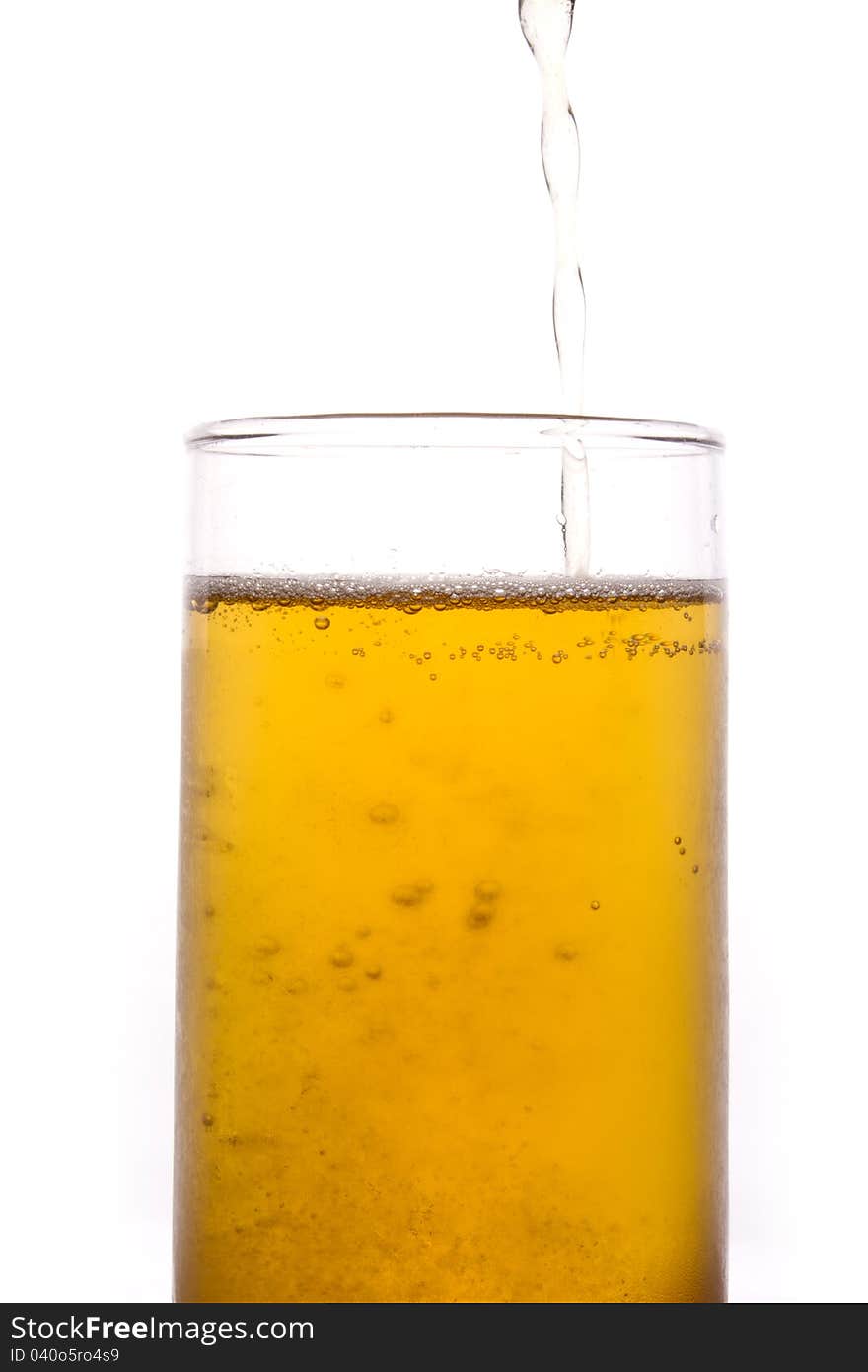 Shot of pouring yellow beer in to a tall glass. Shot of pouring yellow beer in to a tall glass.