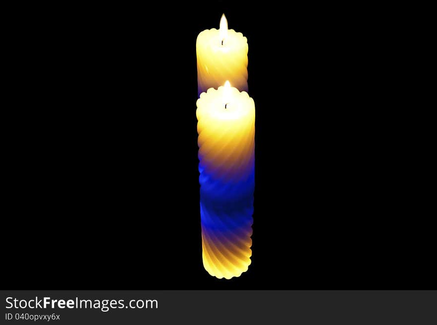 Colored candle on a black background. double reflection. Colored candle on a black background. double reflection