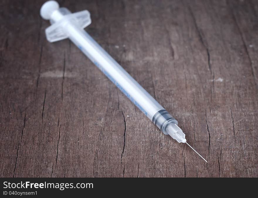 Syringe on wooden table