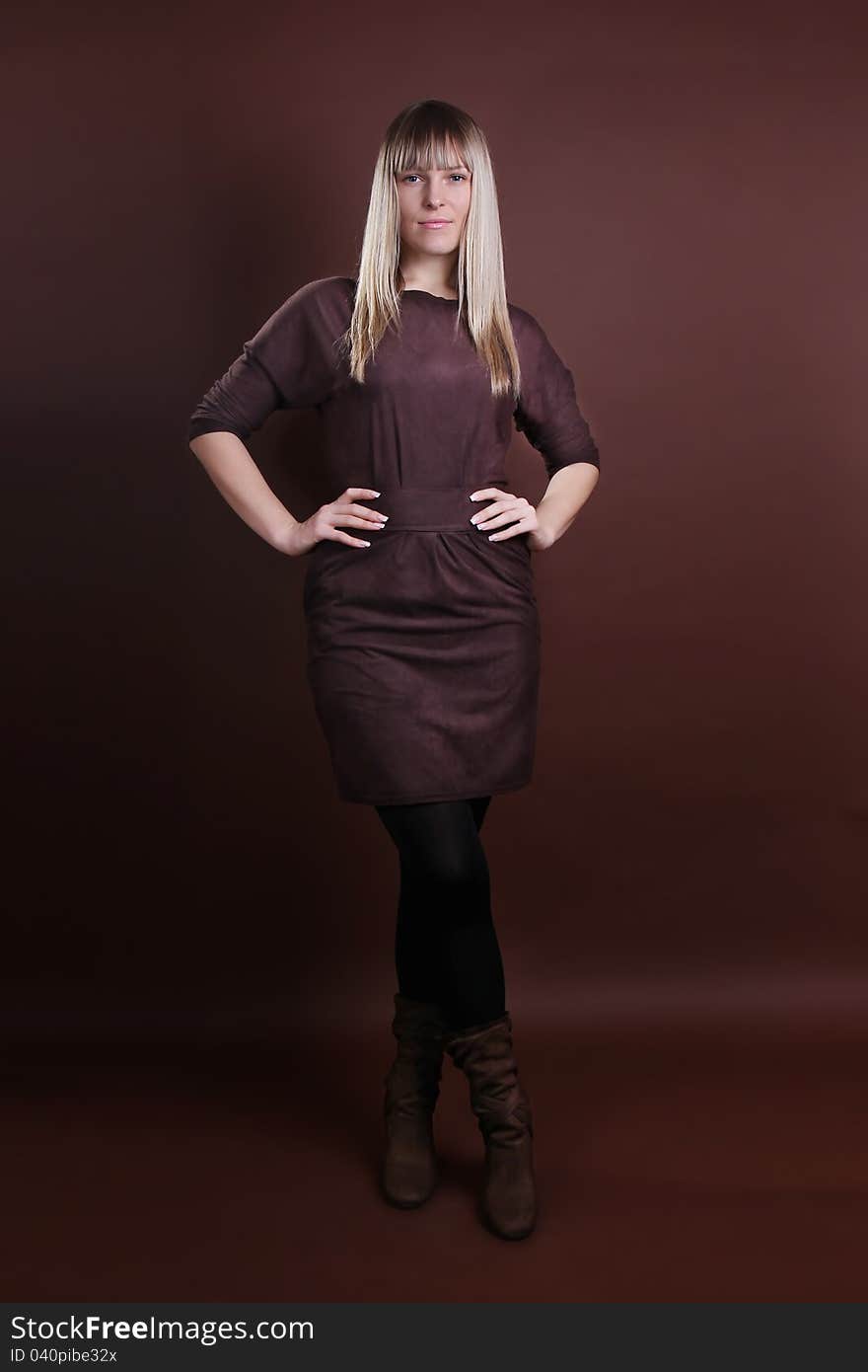 Young woman in full length on a brown background. Young woman in full length on a brown background