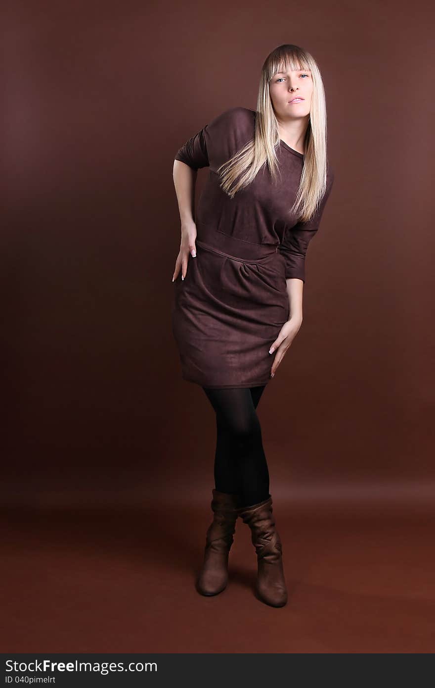 Young woman in full length on a brown background. Young woman in full length on a brown background