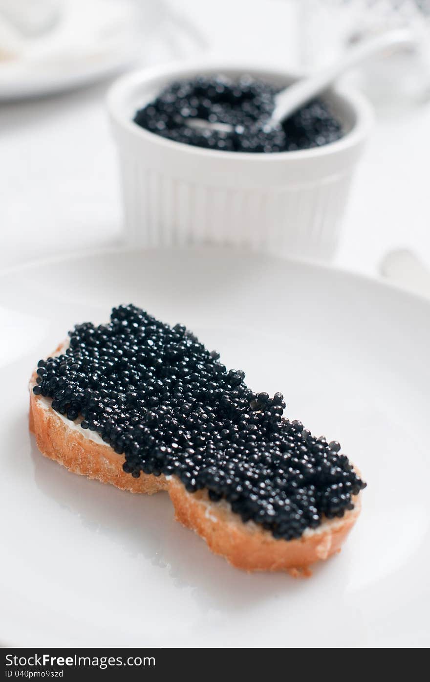 White bread with caviar on a ceramic plate