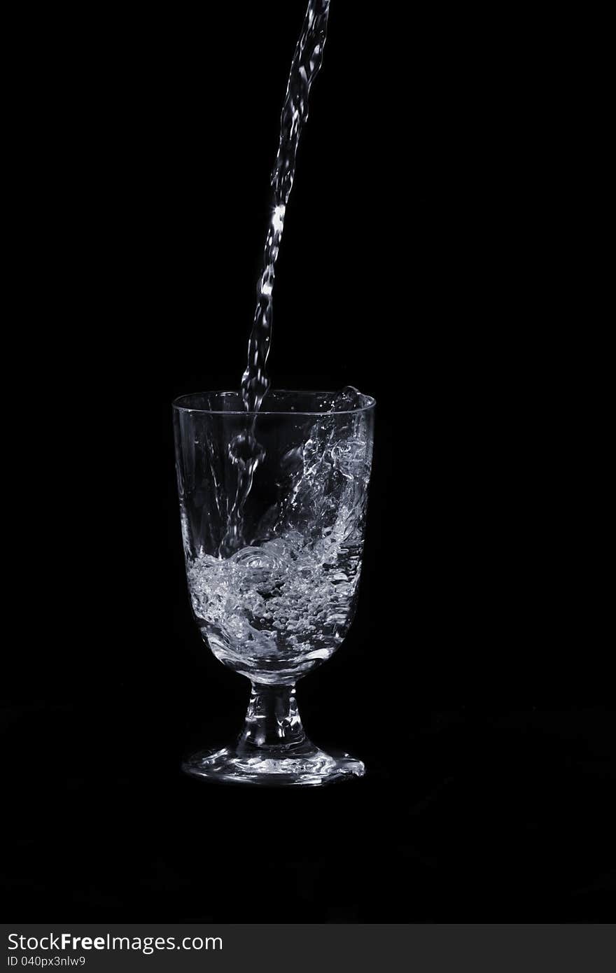 With water splash and transparent glass, on black background. With water splash and transparent glass, on black background.