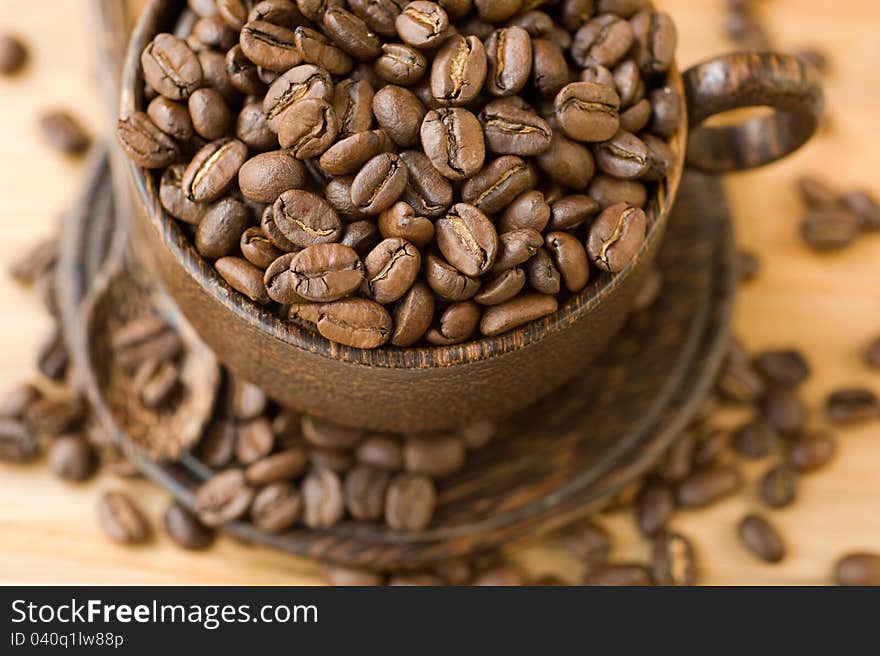 Beans of coffee in a cup and saucer. Beans of coffee in a cup and saucer