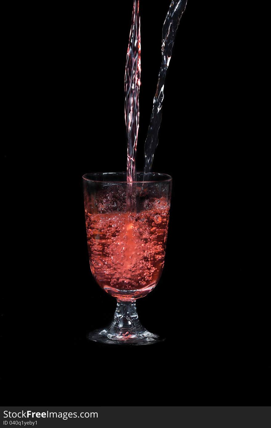 Pouring red and plain water into a glass, on black background. Pouring red and plain water into a glass, on black background.