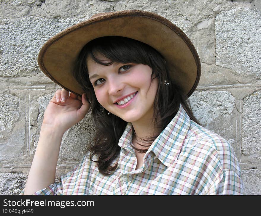 Young cowgirl near the wall