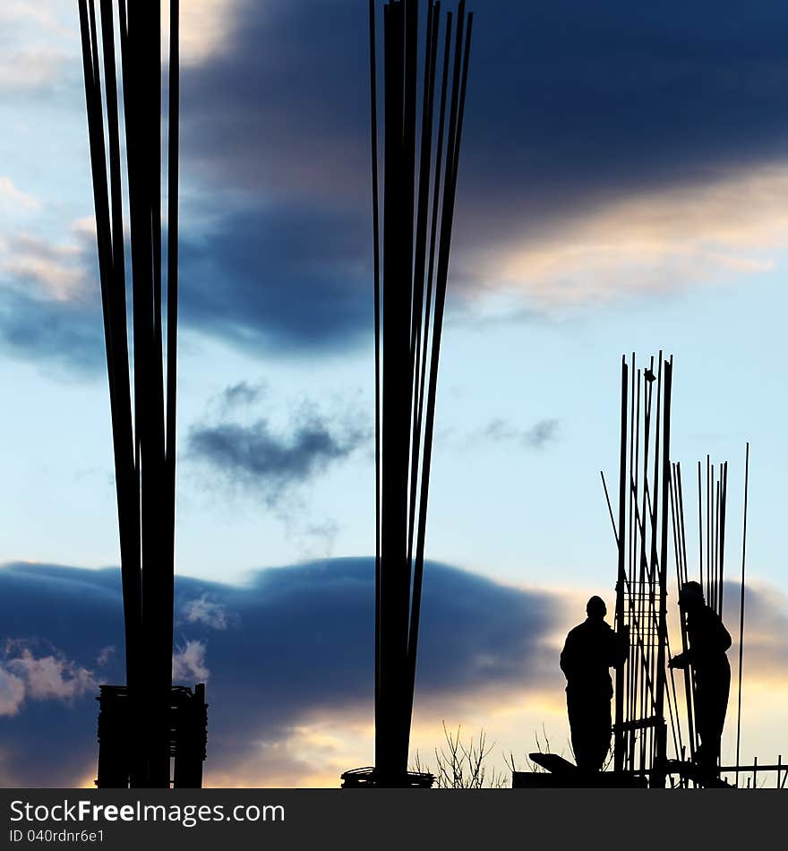 Silhouette of workers and unfinished building. Silhouette of workers and unfinished building