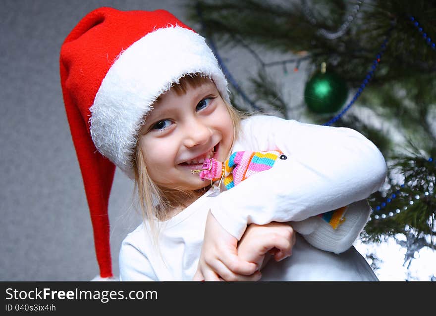 Happy little girl in a Christmas hat in the home. Happy little girl in a Christmas hat in the home