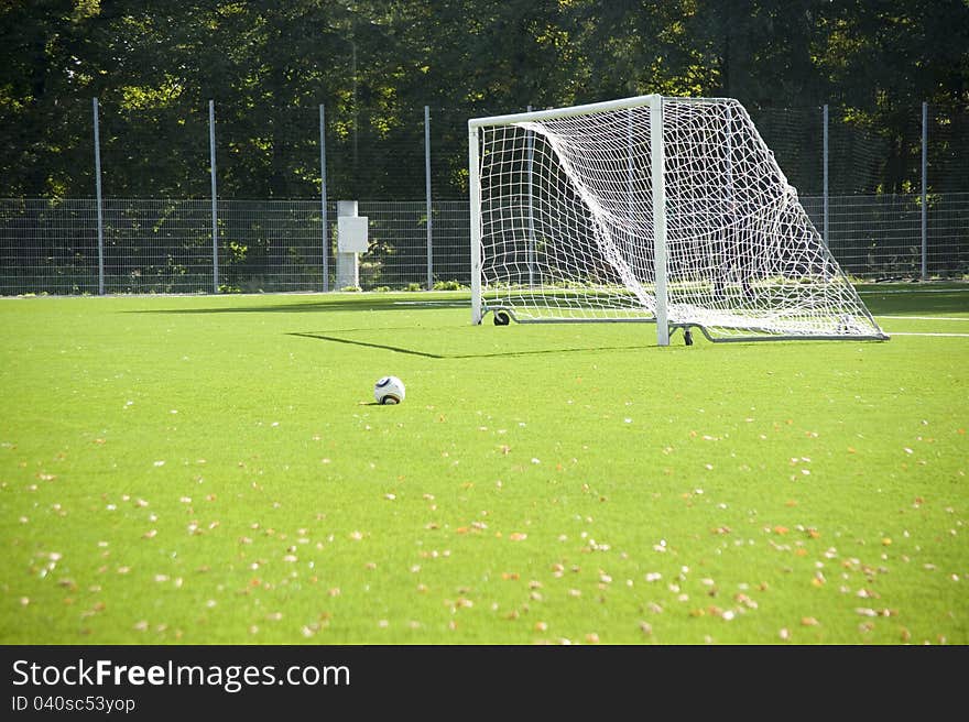 Football. A ball on a grass and football gate.