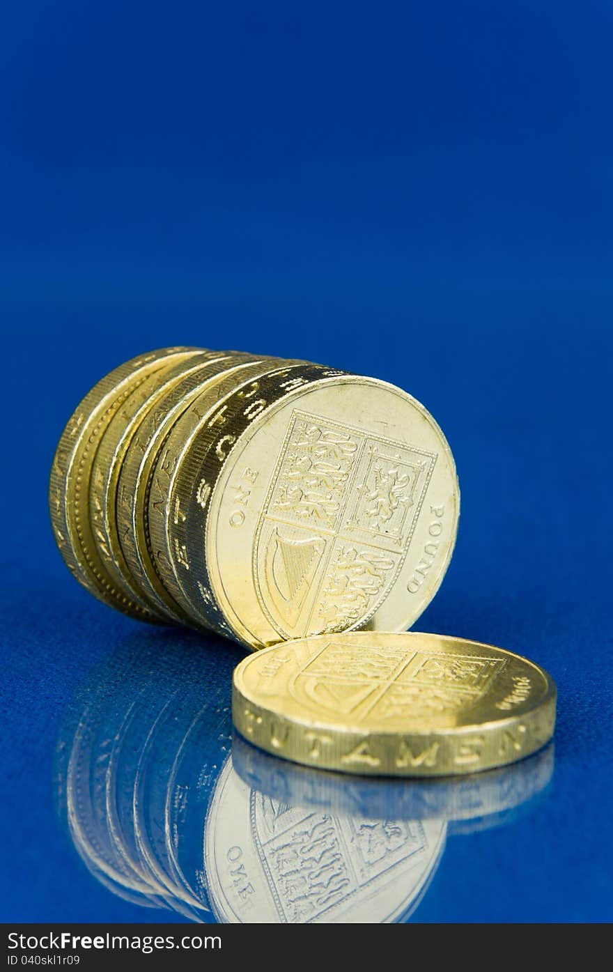 Row of coins with reflection  on blue background. Row of coins with reflection  on blue background