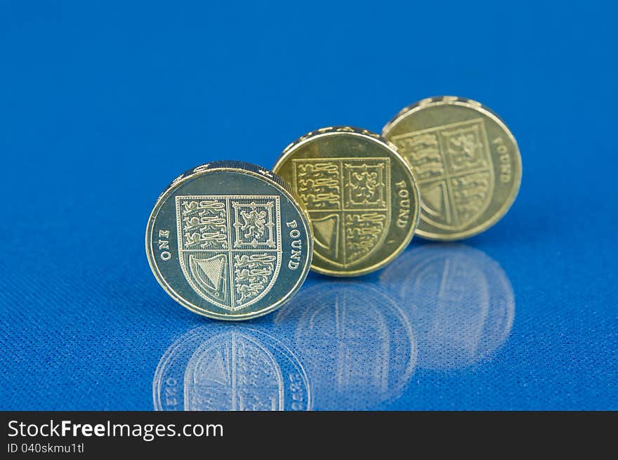 Row of coins with reflection on blue background. Row of coins with reflection on blue background