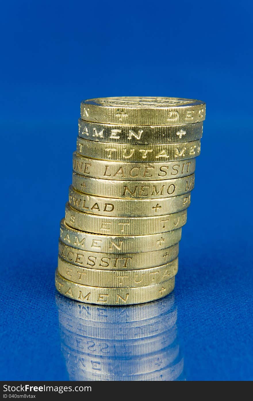 Pile of coins on blue background with reflection. Pile of coins on blue background with reflection