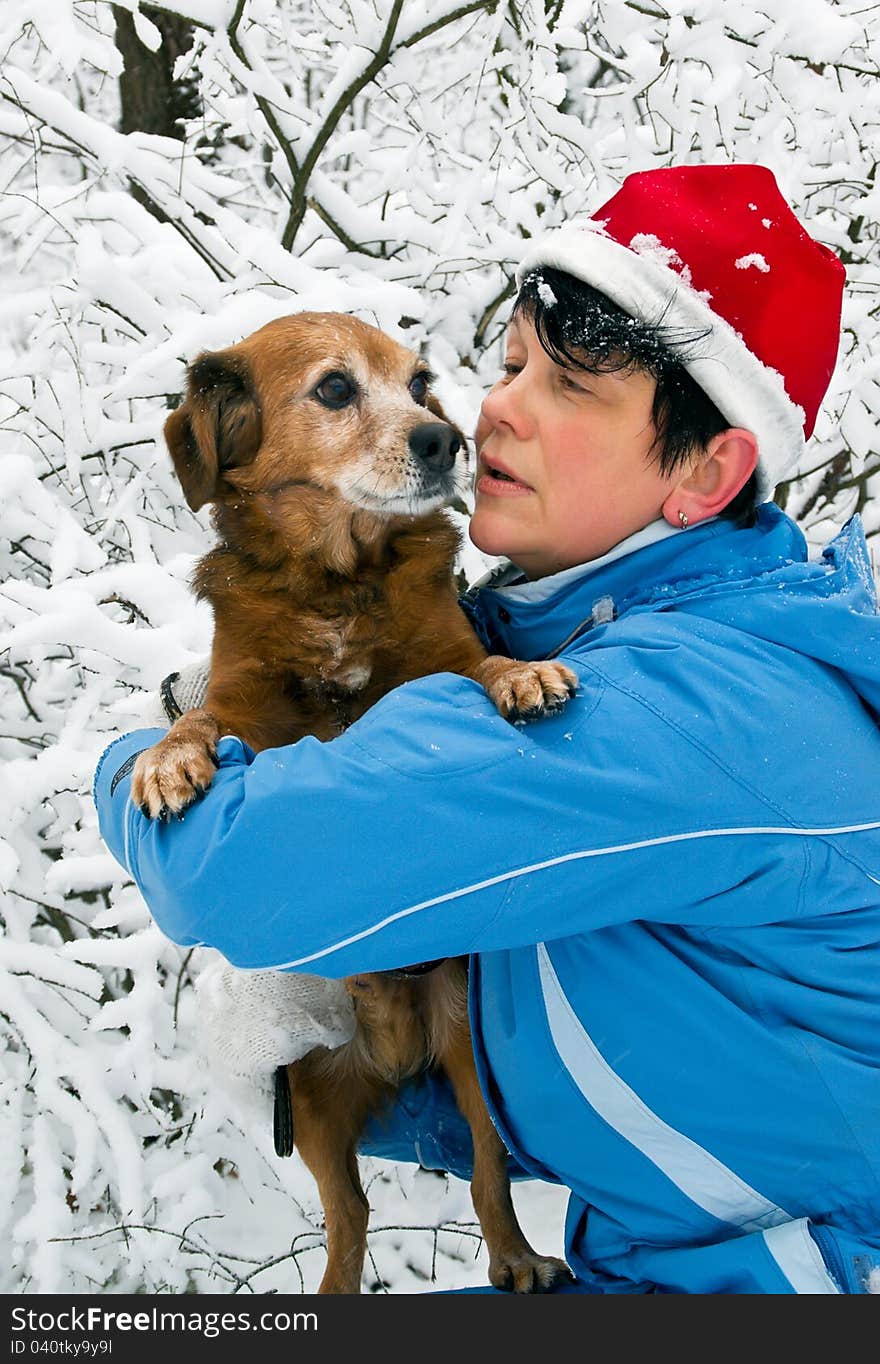 Woman with dog walks in snow wood