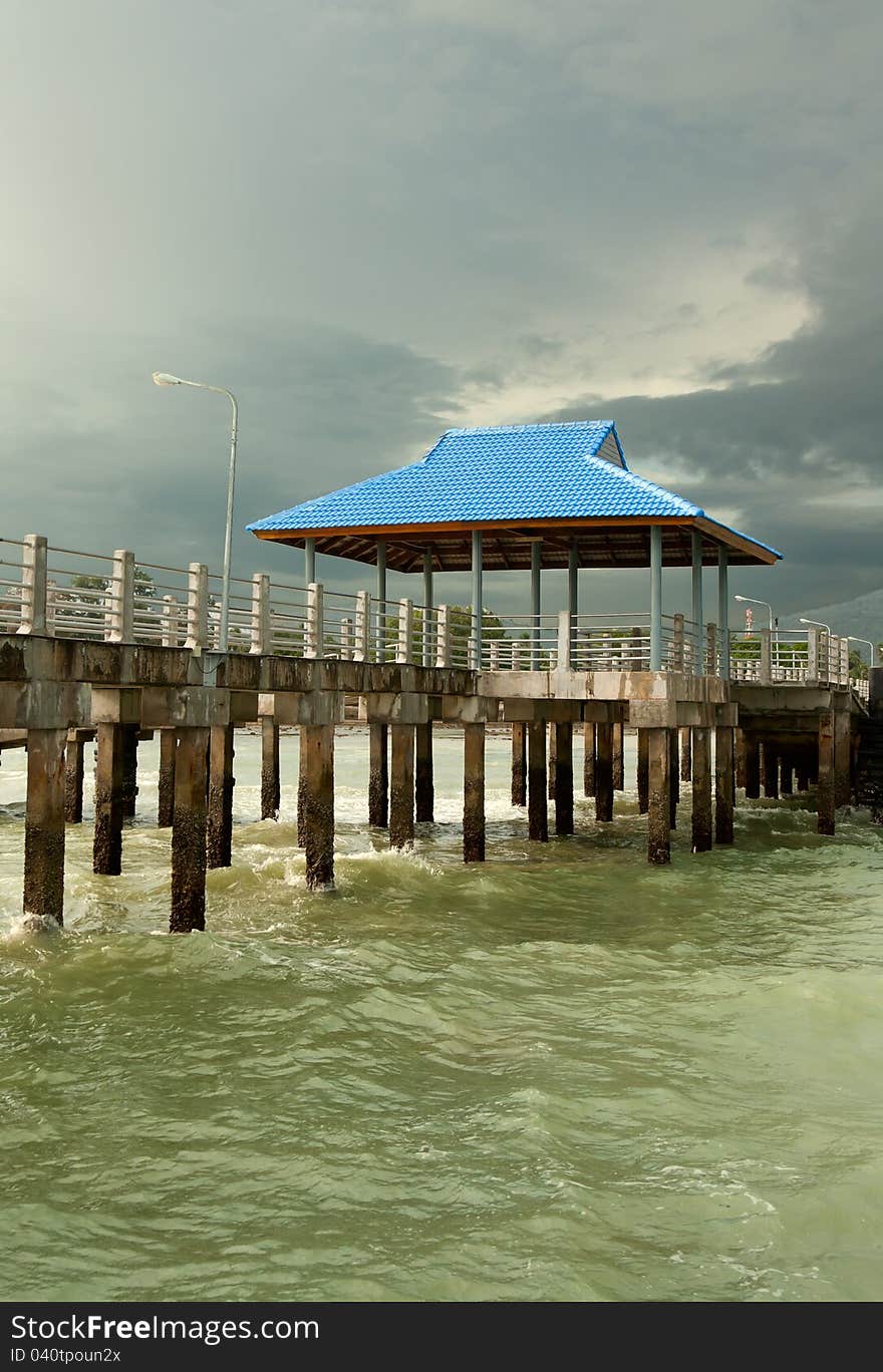 Pier on piles against overcast sky