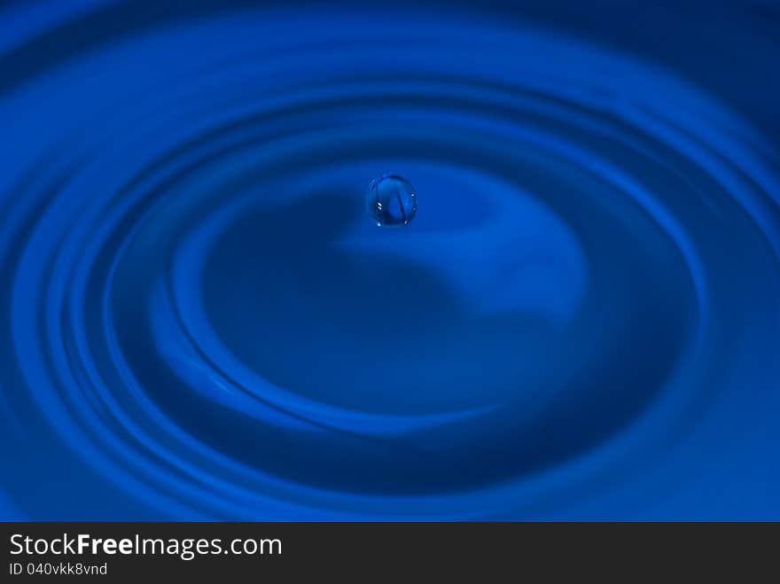 The round transparent blue drop of water