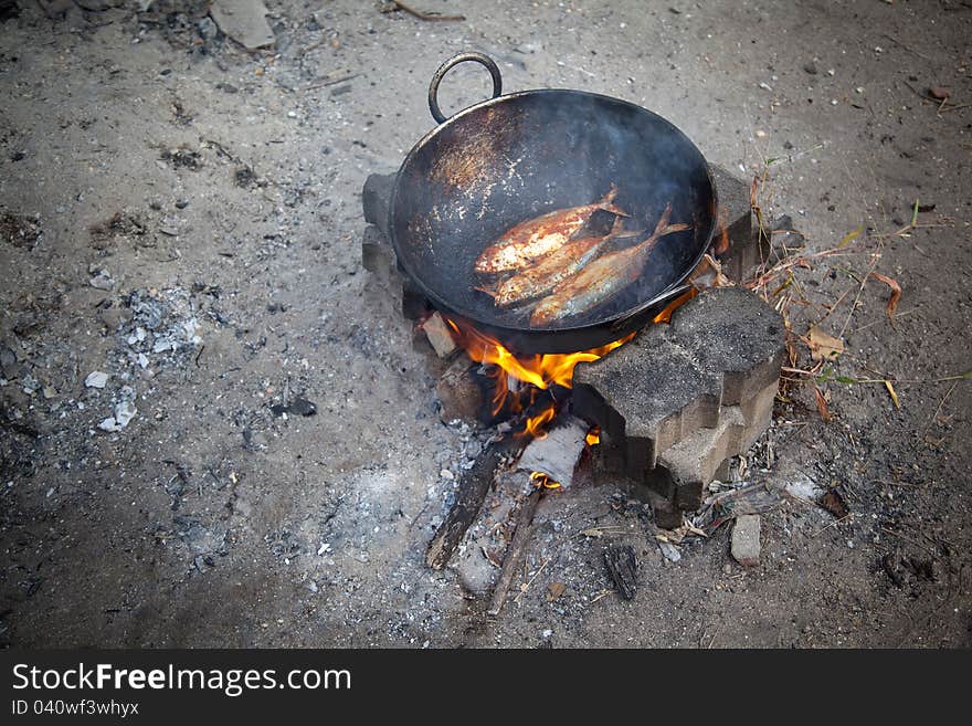 Frying fish in open