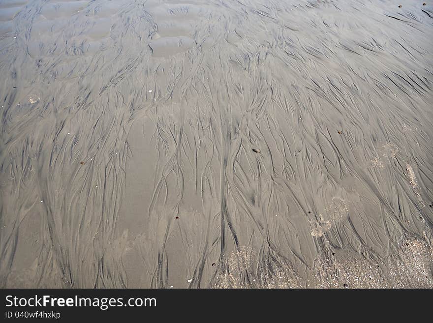 Close up of some wet mud and sand of beach with some water lines. Close up of some wet mud and sand of beach with some water lines