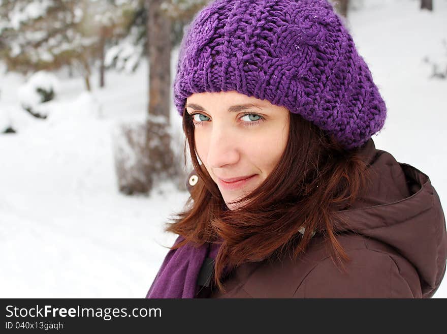 Girl Wearing Purple Hat, Smiling, In A Park Covered With Snow