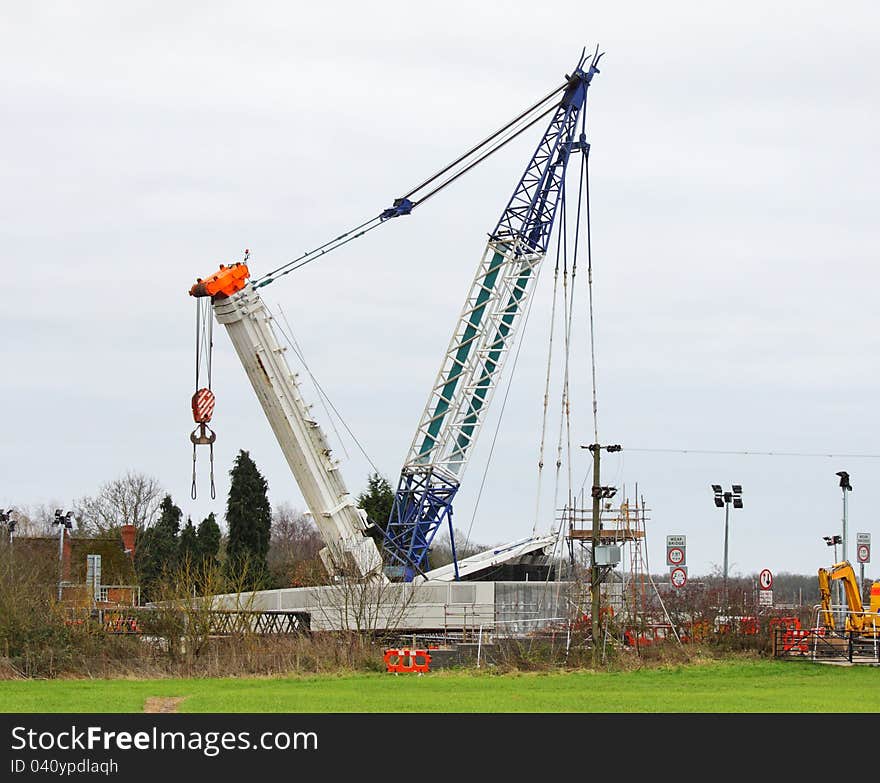 Heavy Duty Crane placing a new Road Bridge over a railway track. Heavy Duty Crane placing a new Road Bridge over a railway track