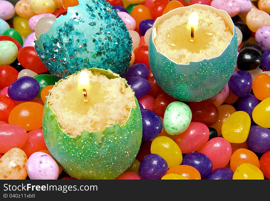 Easter decoration - colorful dyed eggshell candles on a background of candy. Easter decoration - colorful dyed eggshell candles on a background of candy.