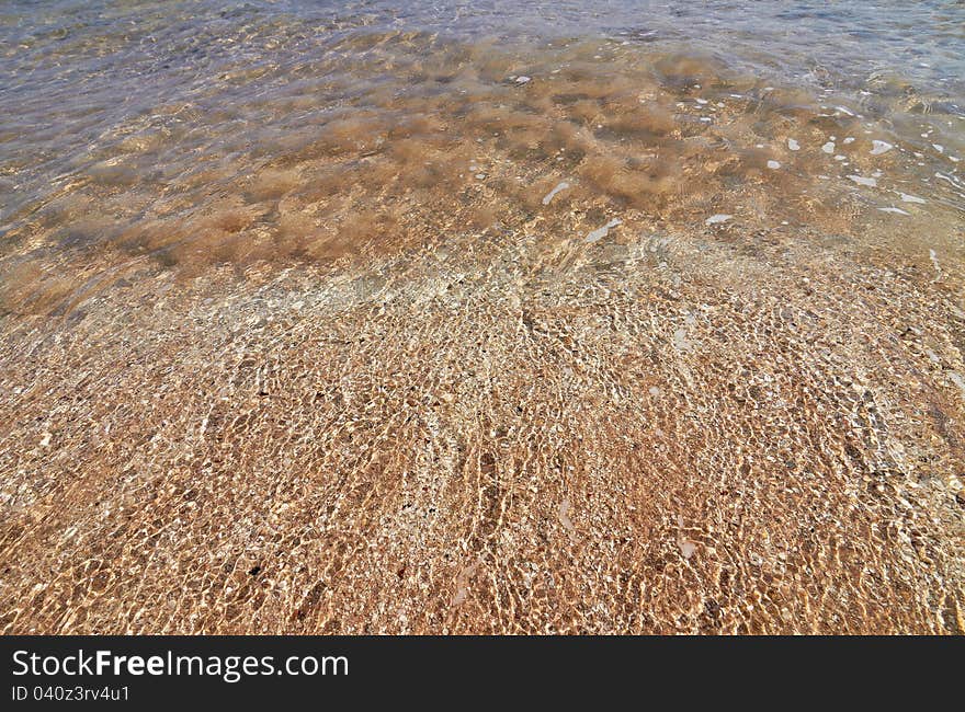 Tranquil sea water motion on a beach as background